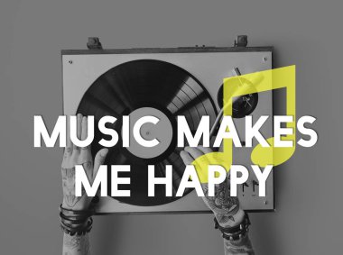 Vinil player ile dövmeli kişi.