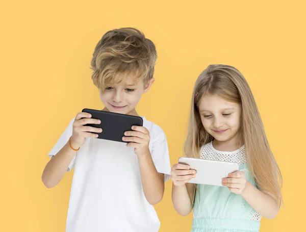 Niños jugando a los teléfonos móviles —  Fotos de Stock