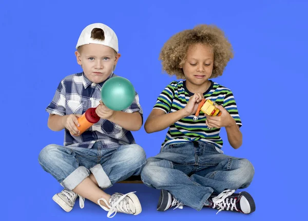 Niños sentados y jugando con juguetes —  Fotos de Stock