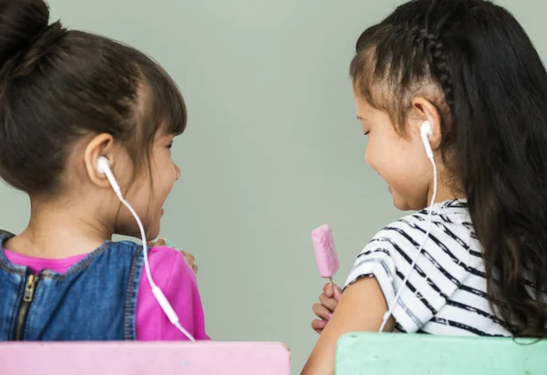 Две девушки слушают музыку в наушниках — стоковое фото