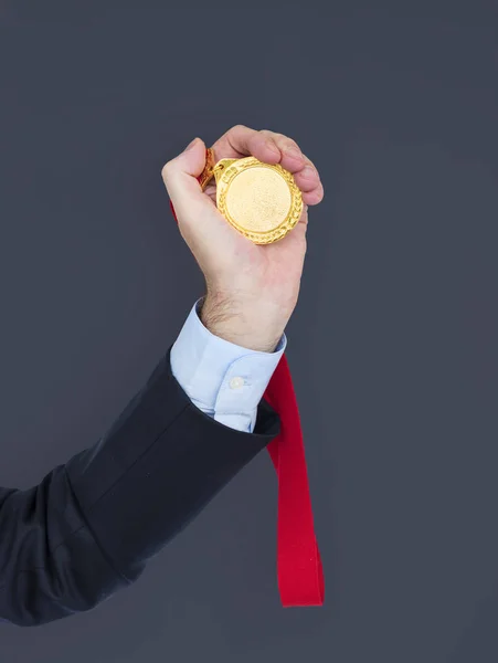 Podnikatel v ruce drží medaile — Stock fotografie