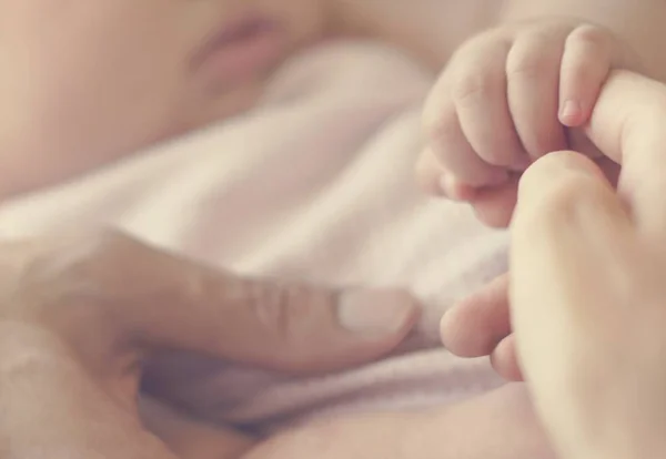 Pasgeboren baby bedrijf vinger van moeder — Stockfoto