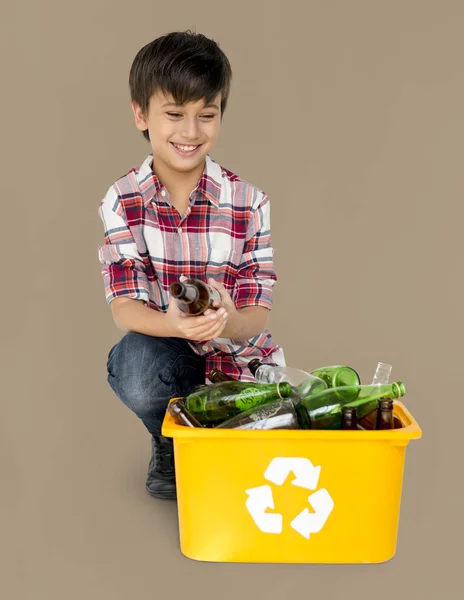 Poika erottamalla kierrätettävät pullot — kuvapankkivalokuva