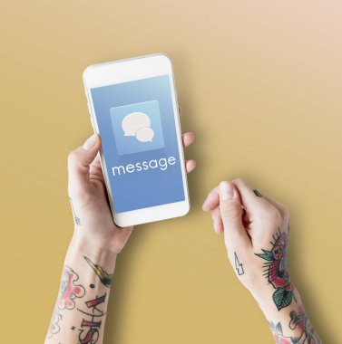 Akıllı telefon kullanan dövmeli kişi.