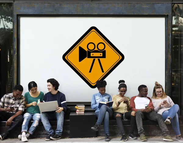 Young students siting near placard — Stock Photo, Image