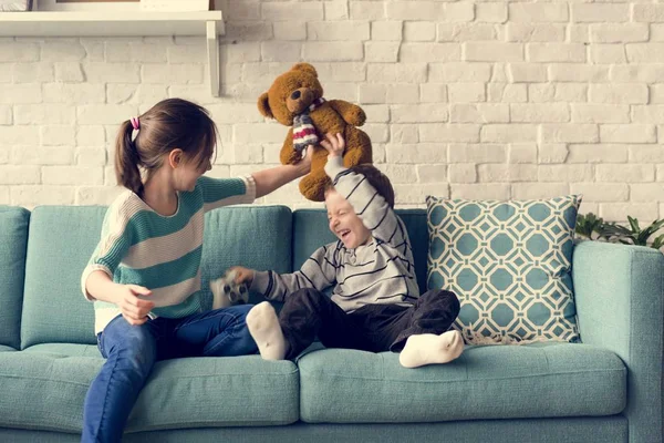 Hermana y hermano jugando con oso — Foto de Stock