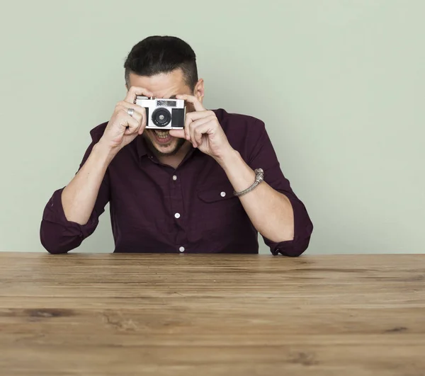 Homem tirando foto na câmera enquanto sentado — Fotografia de Stock