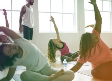 İnsanlar yoga sınıfında germe