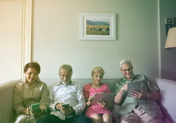 Anziani che utilizzano dispositivi digitali — Foto Stock