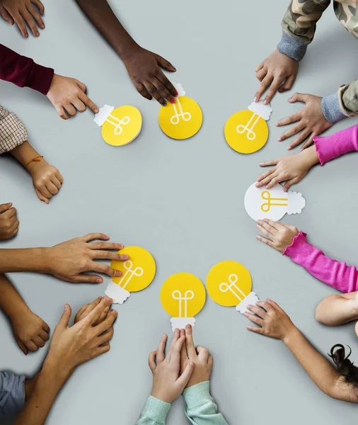 Children hands holding light bulbs — Stock Photo, Image