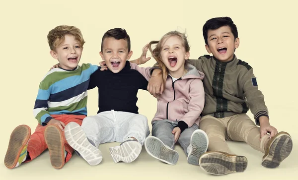 Crianças sorridentes sentadas no chão T — Fotografia de Stock