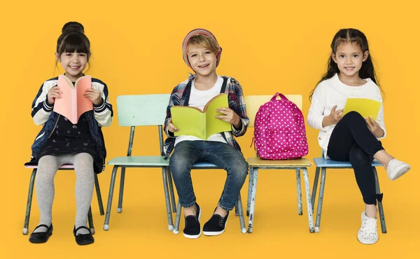 Kinderen zitten op stoelen met boeken — Stockfoto