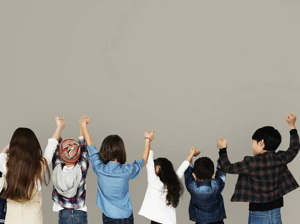 Niños sosteniendo brazos levantados — Foto de Stock