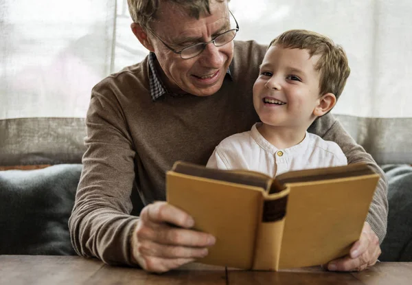 Дедушка и внук читают книгу — стоковое фото