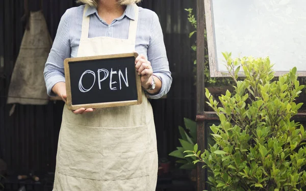 Senior woman holding open sign — Stock Photo, Image