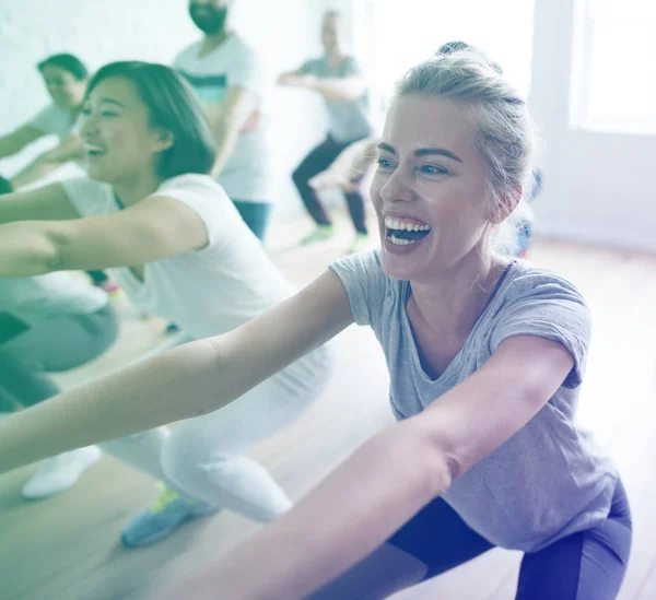 Gente estirándose en clase de yoga — Foto de Stock