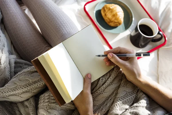 Frau schreibt in Buch — Stockfoto