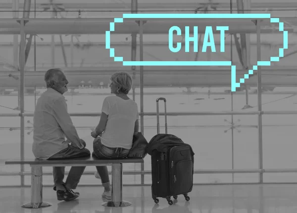 Casal sênior sentado no banco no aeroporto — Fotografia de Stock