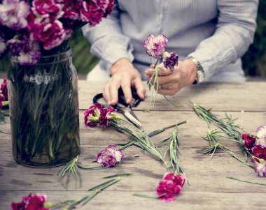 Olgun Bayan çiçek düzenliyor