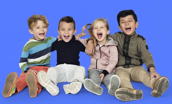 Niños sonrientes sentados en el suelo T —  Fotos de Stock