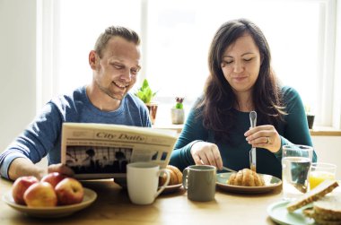 Çift evde kahvaltı yapıyor.
