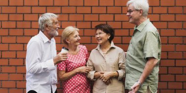 tuğla duvarın önünde konuşan üst düzey insanlar