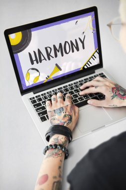 Dövmeli kişi dizüstü bilgisayarda yazarak.