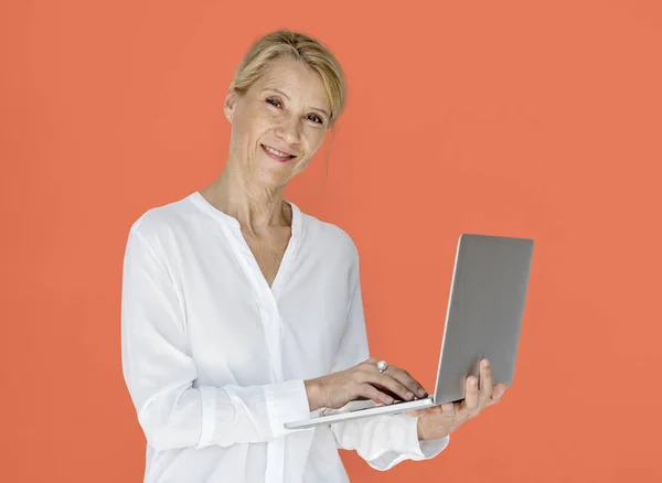 Frau benutzt Laptop und schaut in Kamera — Stockfoto