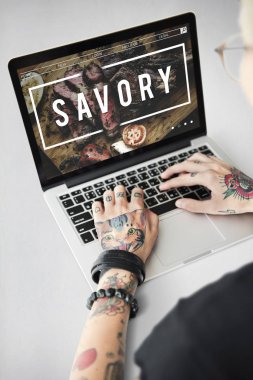 Dövmeli kişi dizüstü bilgisayarda yazarak.