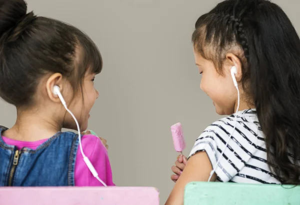 Duas meninas ouvindo música em fones de ouvido — Fotografia de Stock