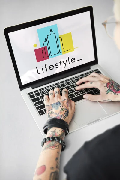 Getatoeëerde persoon typen op laptop. — Stockfoto