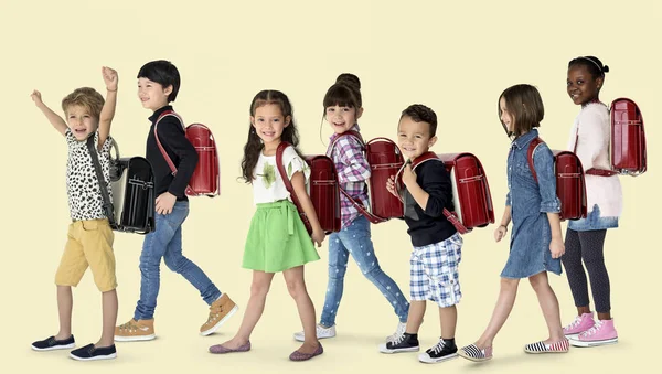 Crianças caminhando para a escola com mochilas — Fotografia de Stock