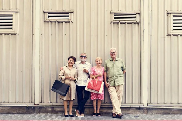 Uśmiechający się starszych ludzi stojących przed ściany — Zdjęcie stockowe