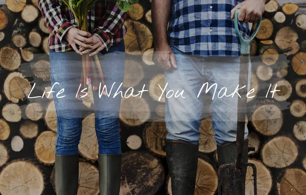 Agricultores em jeans e botas com lenha — Fotografia de Stock