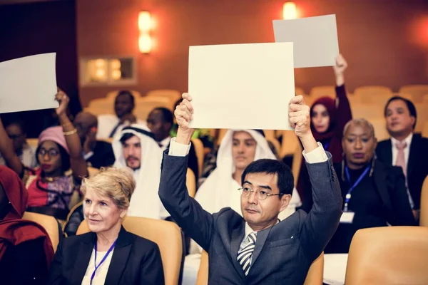 Internationale mensen zitten in publiek — Stockfoto