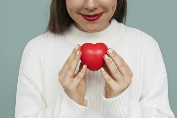 Femme tenant jouet coeur rouge — Photo