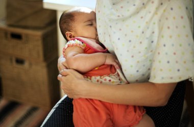 Anne yeni doğan bebeği besliyor.