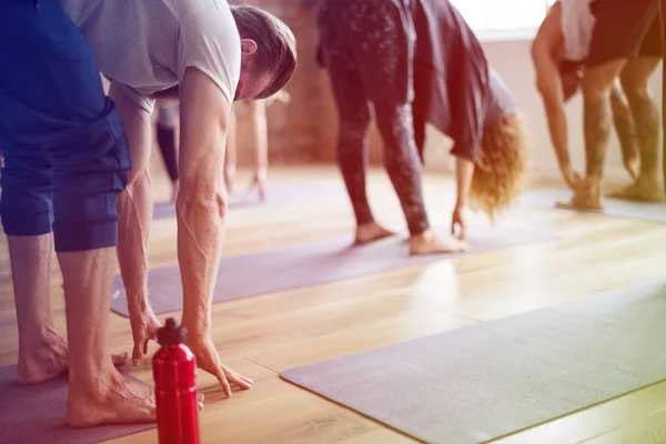 Gente estirándose en clase de yoga — Foto de Stock