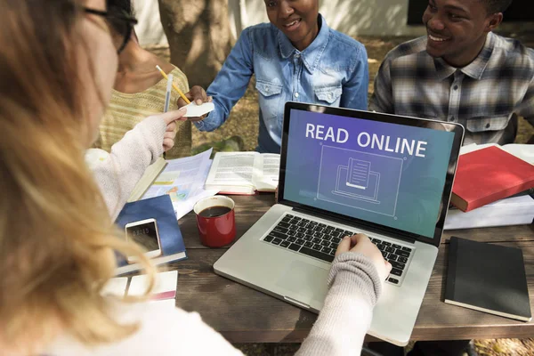 Students sitting at table with books and laptop — Stock Photo, Image