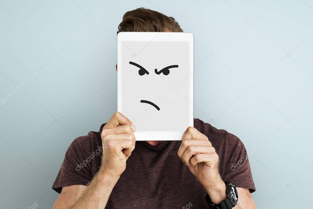 man holding digital tablet covering face