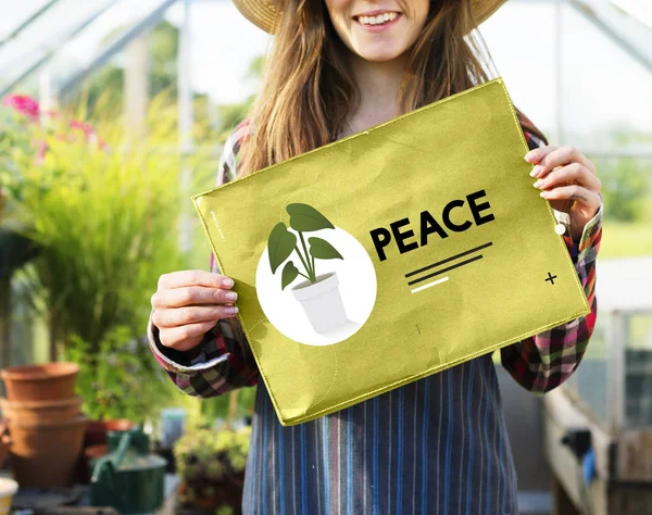 Mujer sosteniendo pancarta de papel en invernadero —  Fotos de Stock