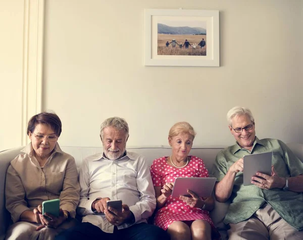 Pessoas idosas usando dispositivos digitais — Fotografia de Stock