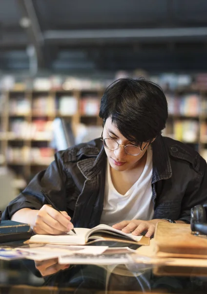 ノートに書いている学生少年 — ストック写真