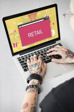 Dövmeli kişi dizüstü bilgisayarda yazarak.