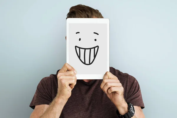 Man holding digital tablet covering face — Stock Photo, Image