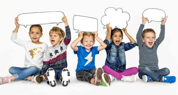 Niños sosteniendo burbujas del habla —  Fotos de Stock