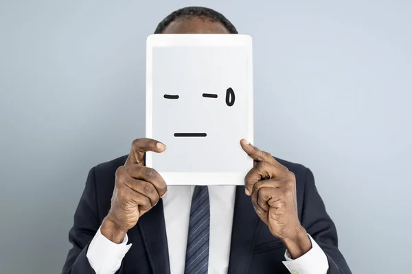 Hombre celebración de la tableta digital que cubre la cara —  Fotos de Stock