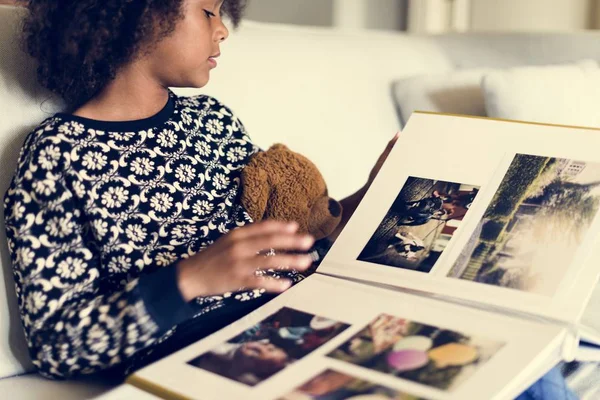 Meisje kijkend naar fotoalbum — Stockfoto