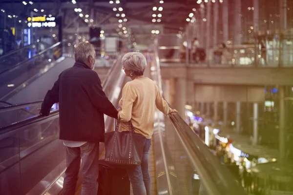 在机场的自动扶梯上的老年旅游市场 — 图库照片
