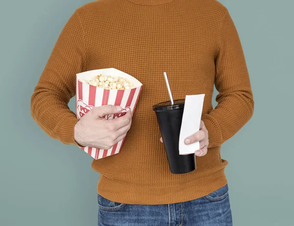Чоловік тримає попкорн і напій з квитком — стокове фото